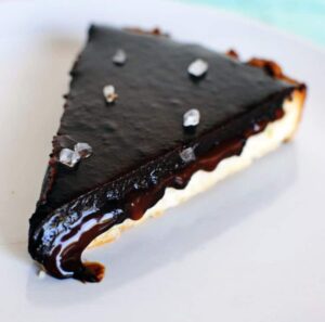 Salted caramel chocolate tart tastes amazingly like a Twix candy bar. Salted caramel and chocolate inside of a tender shortbread crust. Get the dessert recipe from PassTheSushi.com