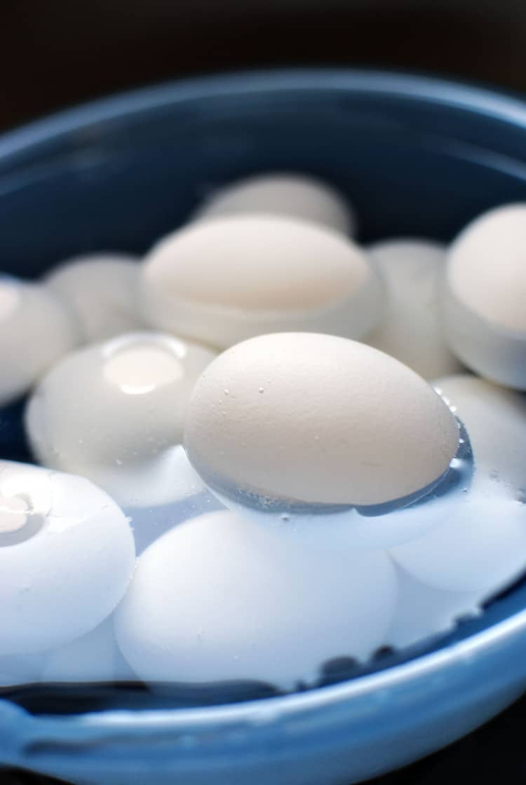 eggs sitting in a water bath after being boiled to cool down.