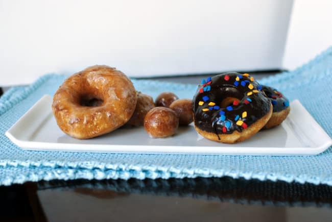 glazed and chocolate covered fried doughnuts on a tray | passthesushi.com