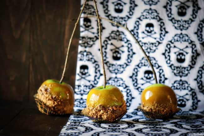 Butterfinger caramel apples will make you the favorite house for Trick or Treat! Tart Granny Smith apples coated with sweet, homemade Butterfinger caramel sauce. \\ PassTheSushi.com