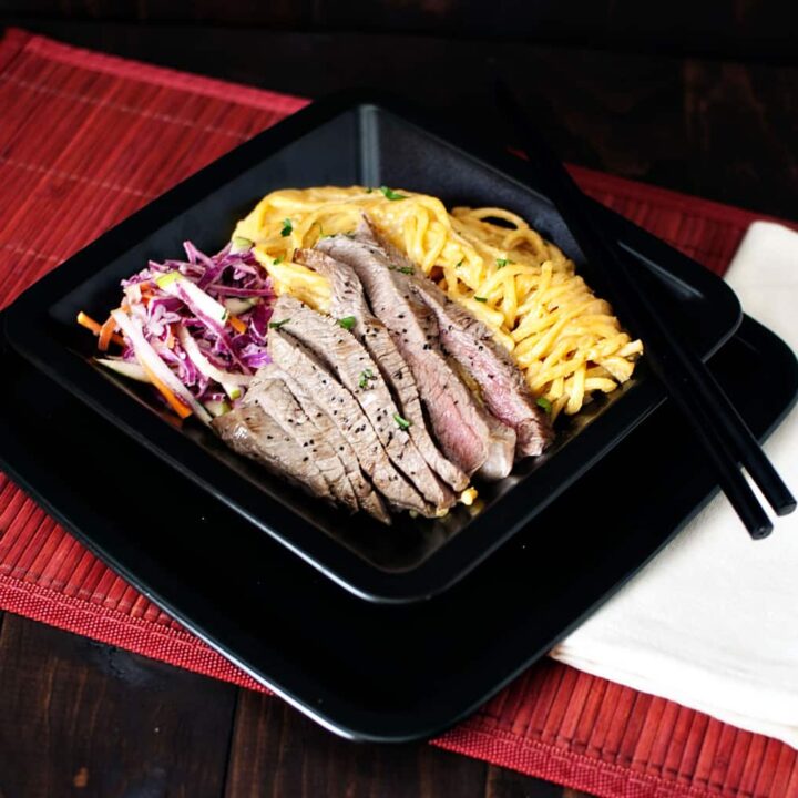 Flank steak, perfectly seasoned and pan seared, sits on a bed of tender egg noodles in a creamy peanut butter sauce. Dinner in 20 minutes! || PassTheSushi.com