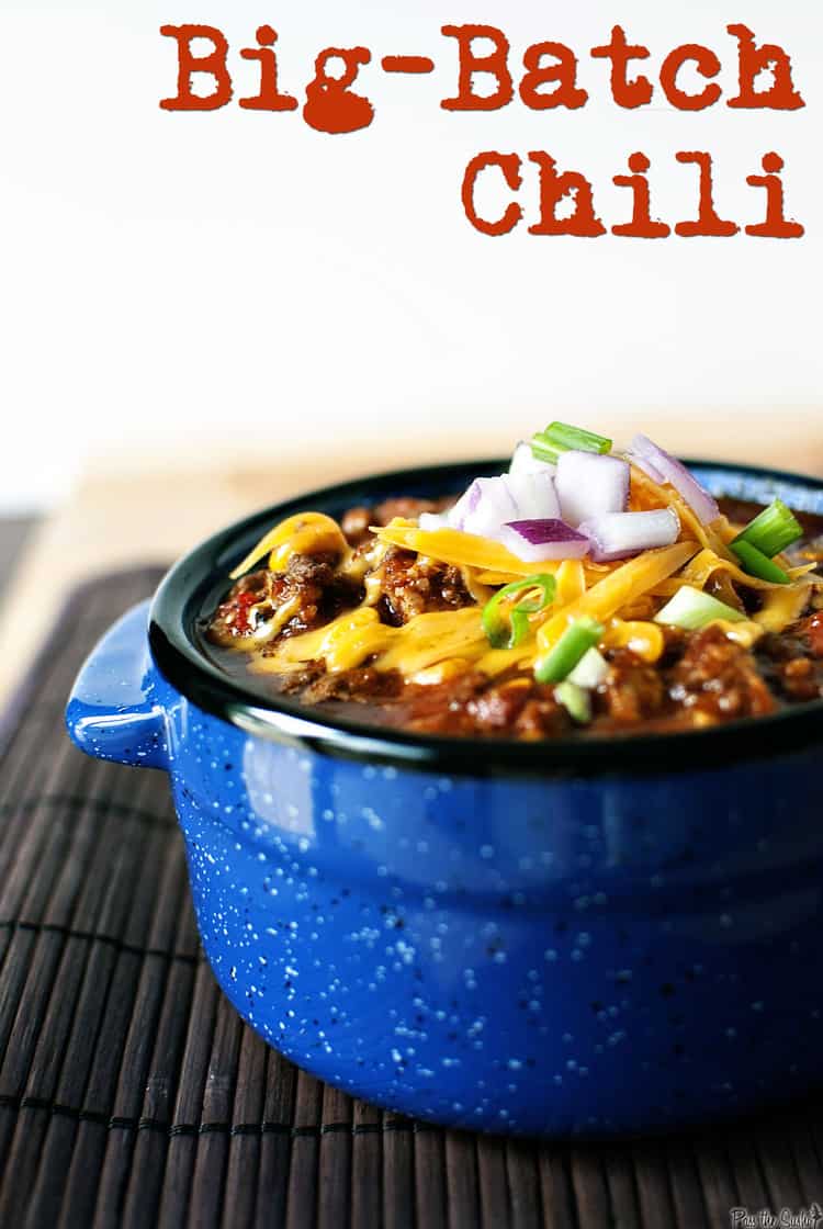 Blue bowl of chili with ground beef and toppings. 