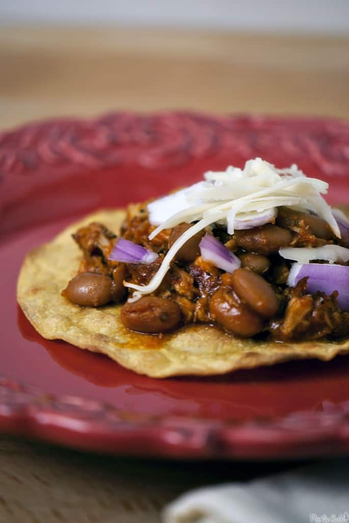 Pork tinga is a Mexican tostada dish made with flavorful shredded pork. It's an easy to prepare, hearty, and filling comfort food dinner. \\ PassTheSushi.com