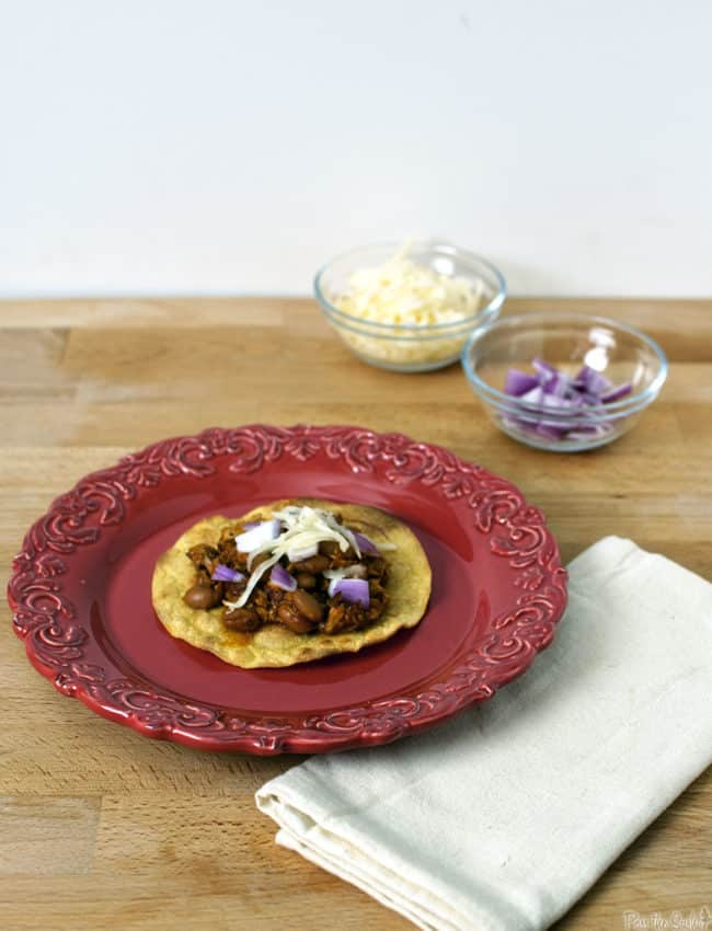 Pork tinga is a Mexican tostada dish made with flavorful shredded pork. It's an easy to prepare, hearty, and filling comfort food dinner. \\ PassTheSushi.com