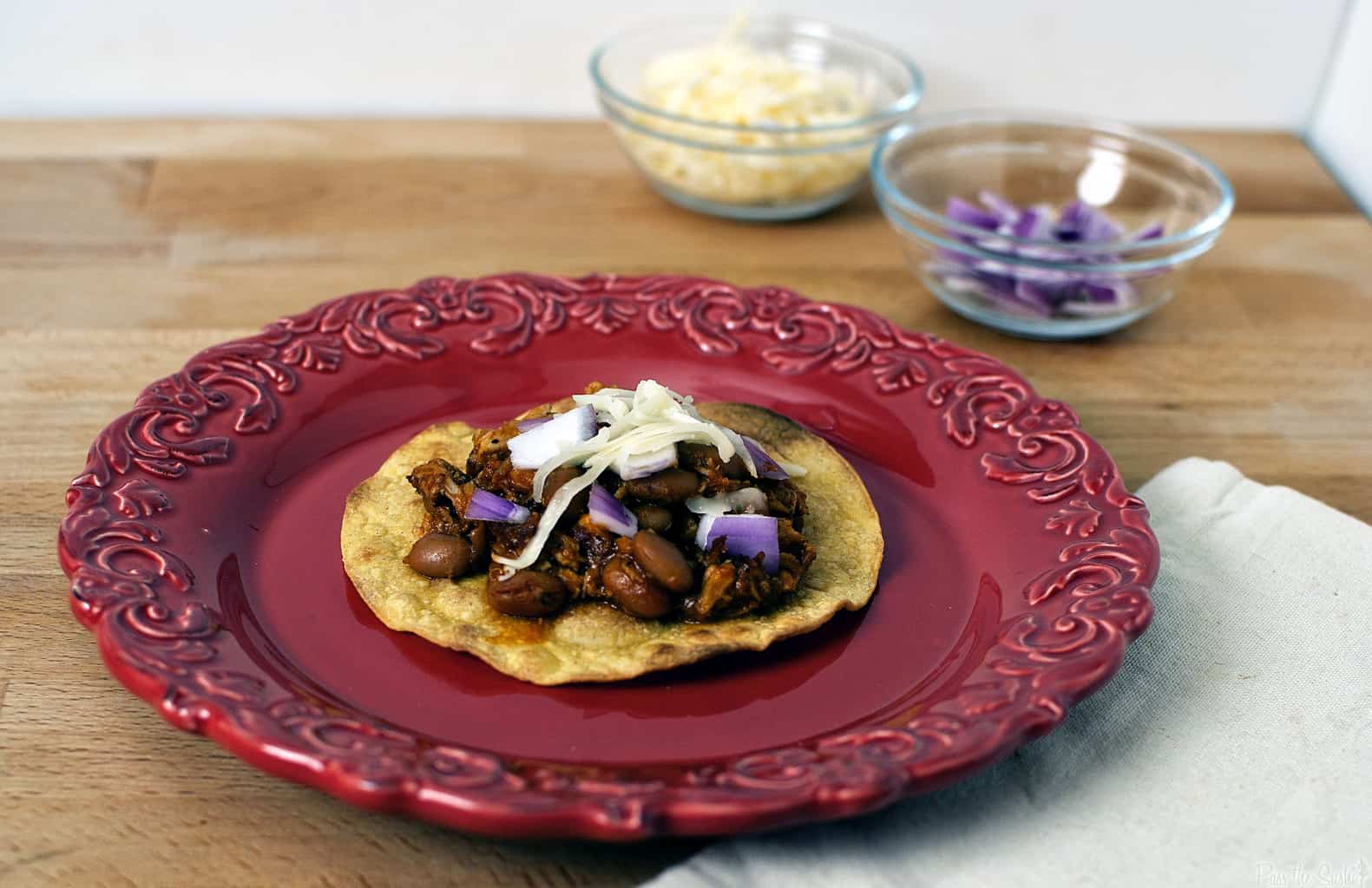 Pork tinga is a Mexican tostada dish made with flavorful shredded pork. It's an easy to prepare, hearty, and filling comfort food dinner. \\ PassTheSushi.com