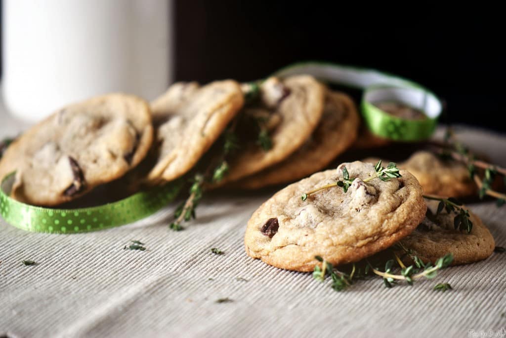 Perfect cookies with crisp edges and thyme sitting on a table with ribbon.