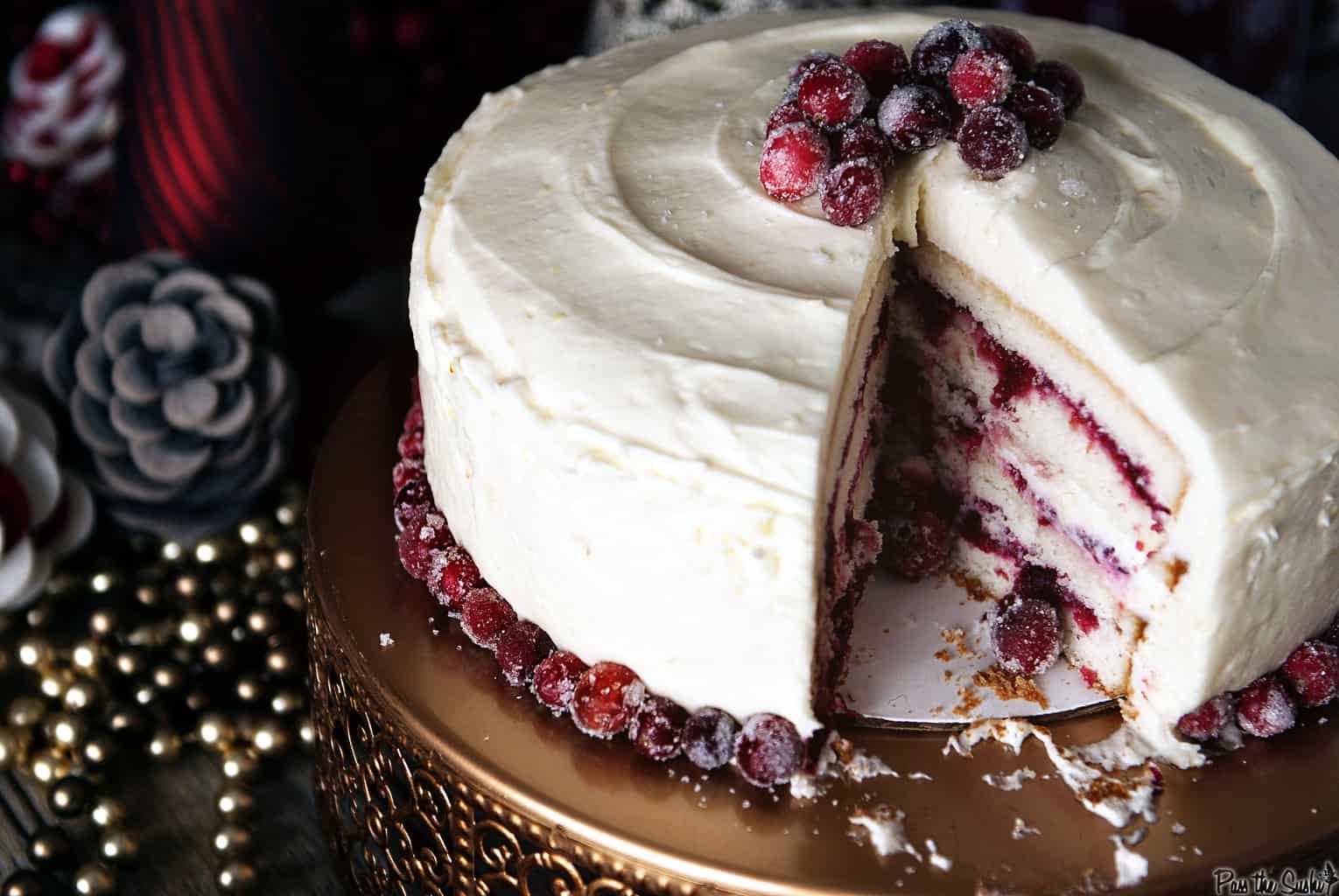 A fun christmas cake with a slice taken out to show cranberry filling in between layers of soft cake. 