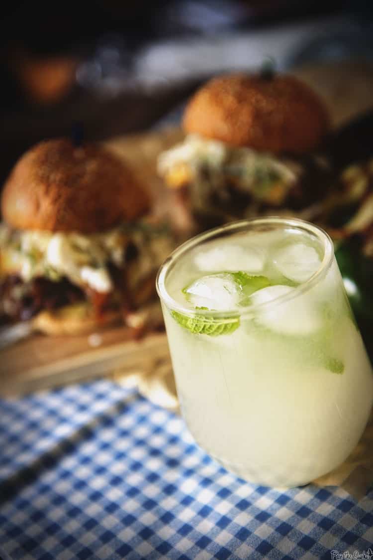 Up-close shot of a cocktail glass on a table with food. 