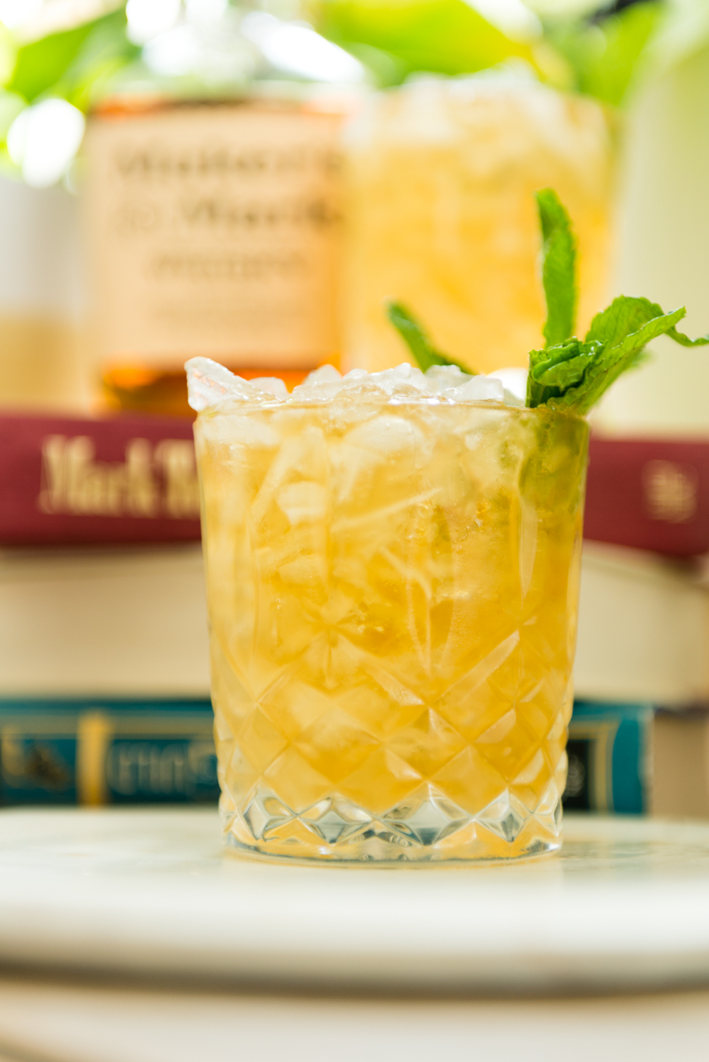 Close up of the cocktail with ice bubbling over the top of a highball glass. 