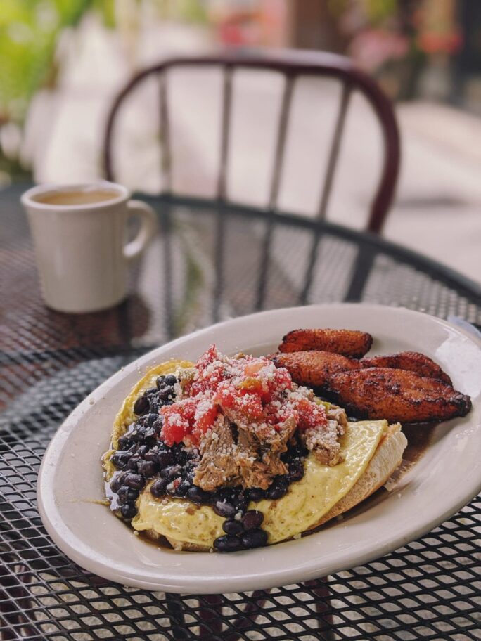 a Cuban breakfast with hearty pulled pork, beans, eggs, toast, and of course fried plantains at Herencia Cafe 