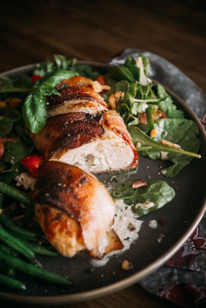 bacon wrapped stuffed chicken breast with salad greens