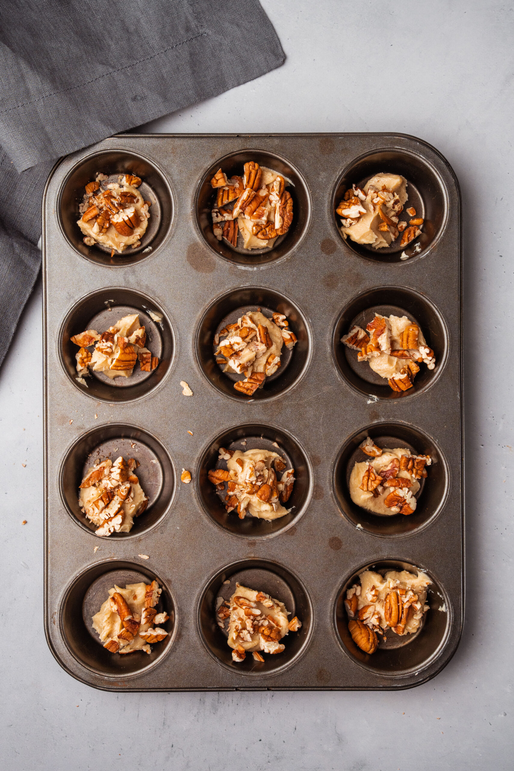 pecans and other ingredients in a muffin pan