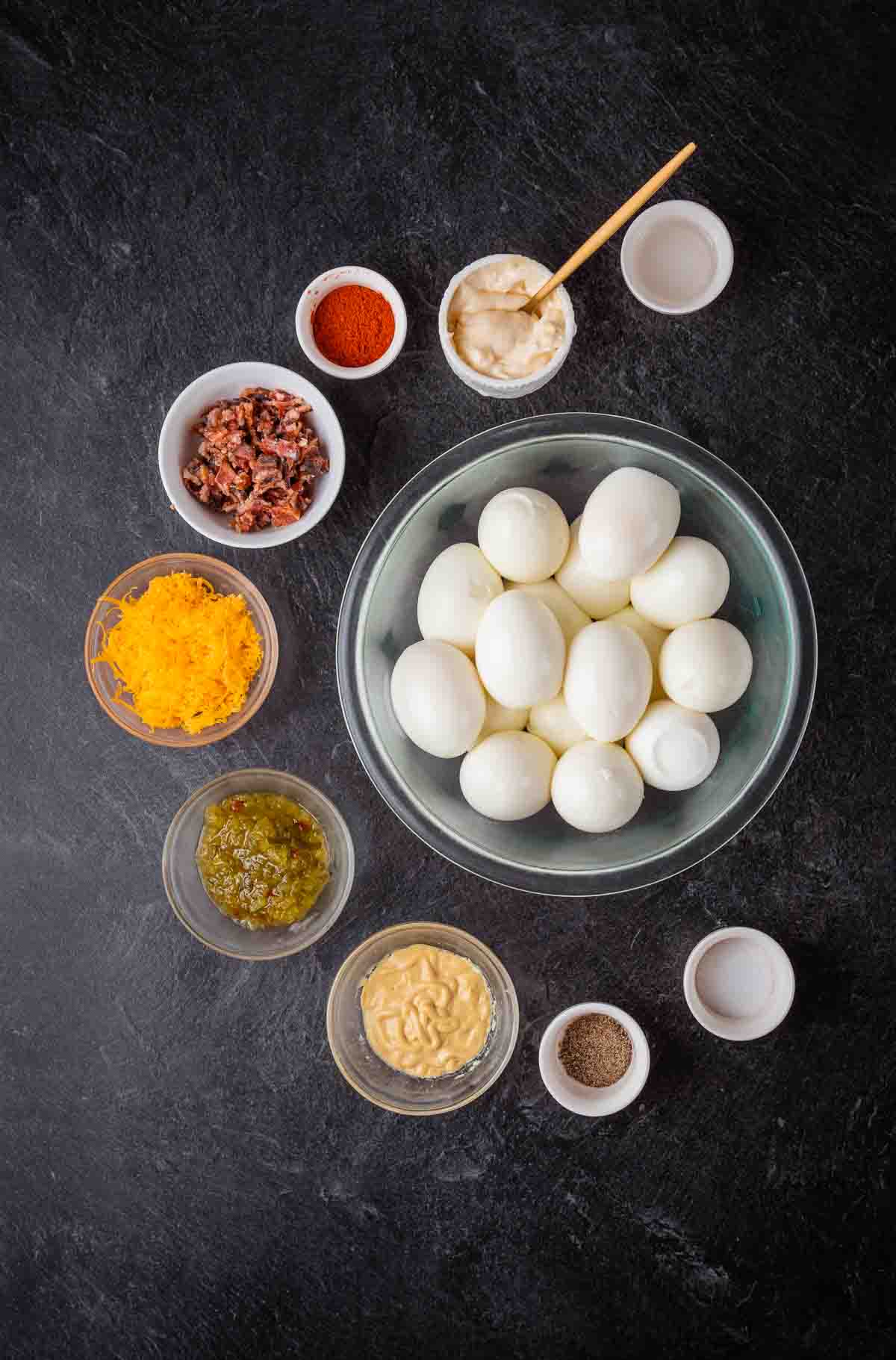 big bowl of eggs surrounded by smaller bowls of ingredients