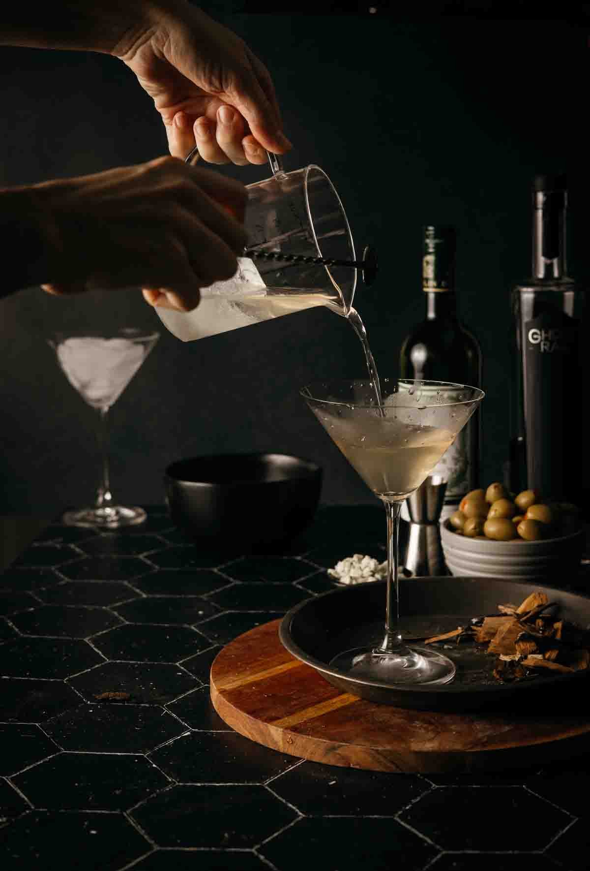 Straining martini into cocktail glass. 