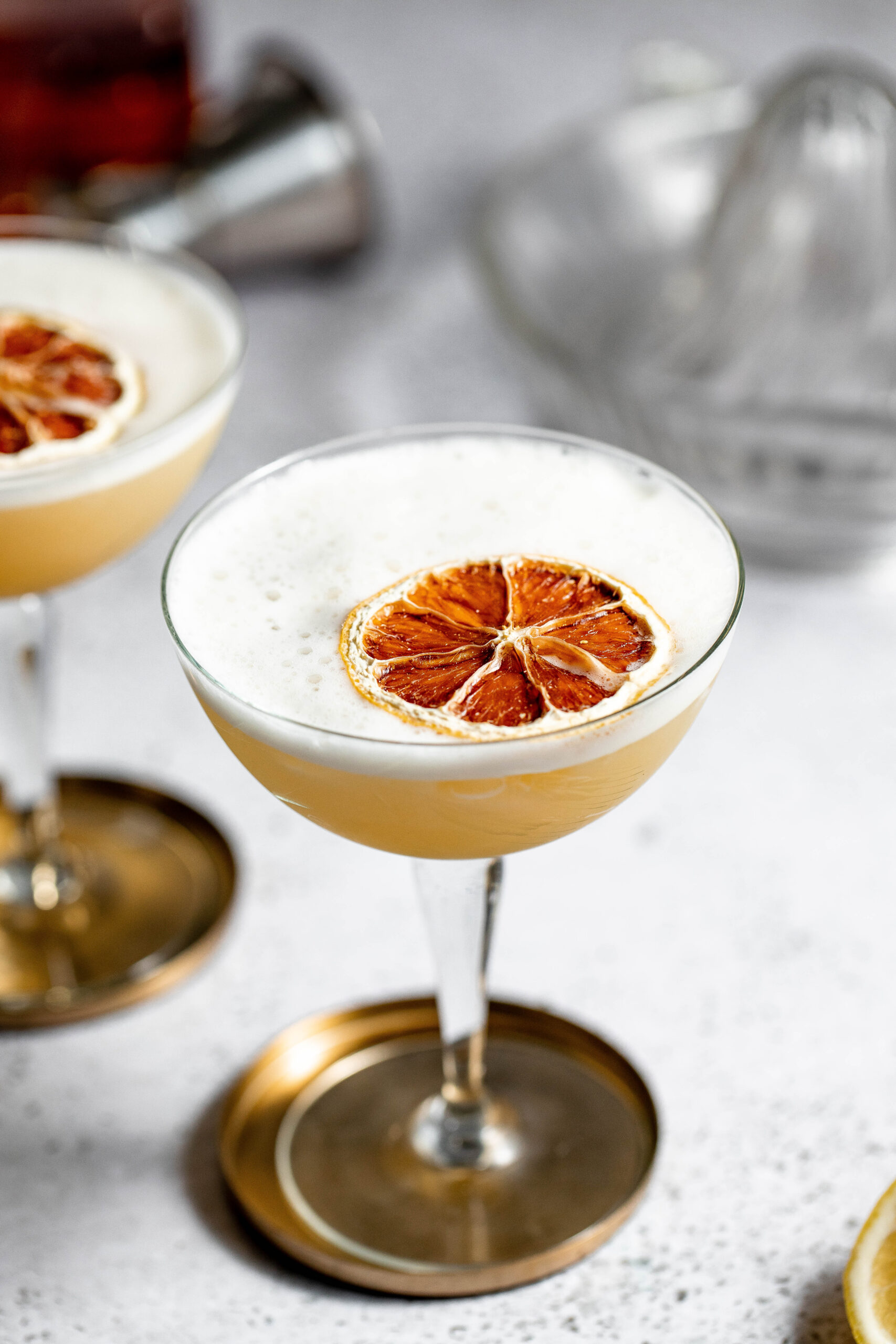 Coupe glass filled with a frothy whiskey sour cocktail 