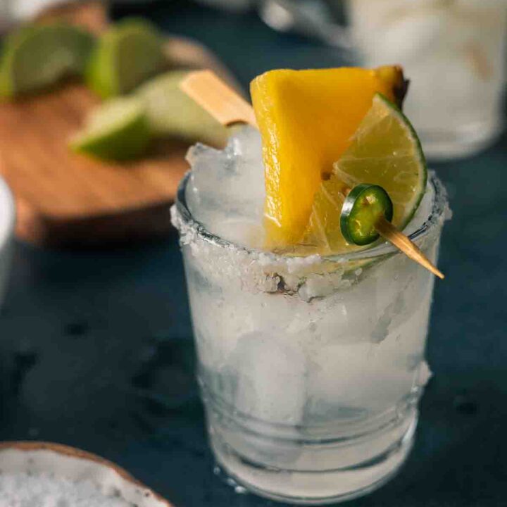 Close up of margarita in a glass with pineapple garnish.