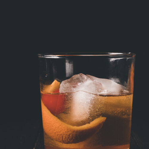 Side shot of a highball glass holding an old fashioned.