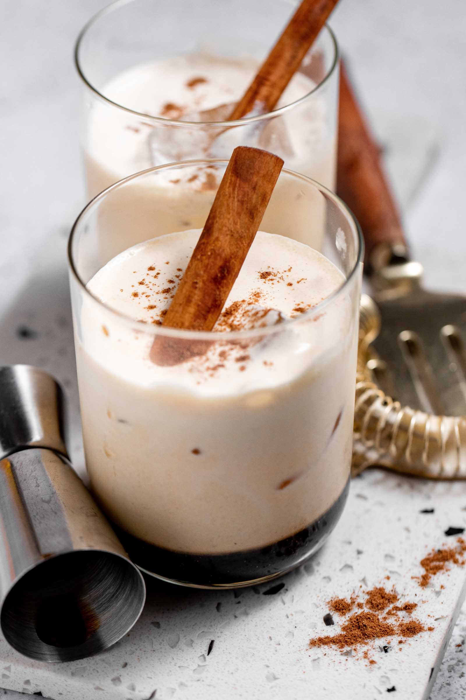 Creamy rich white russian cocktails with cinnamon sticks and garnish. 
