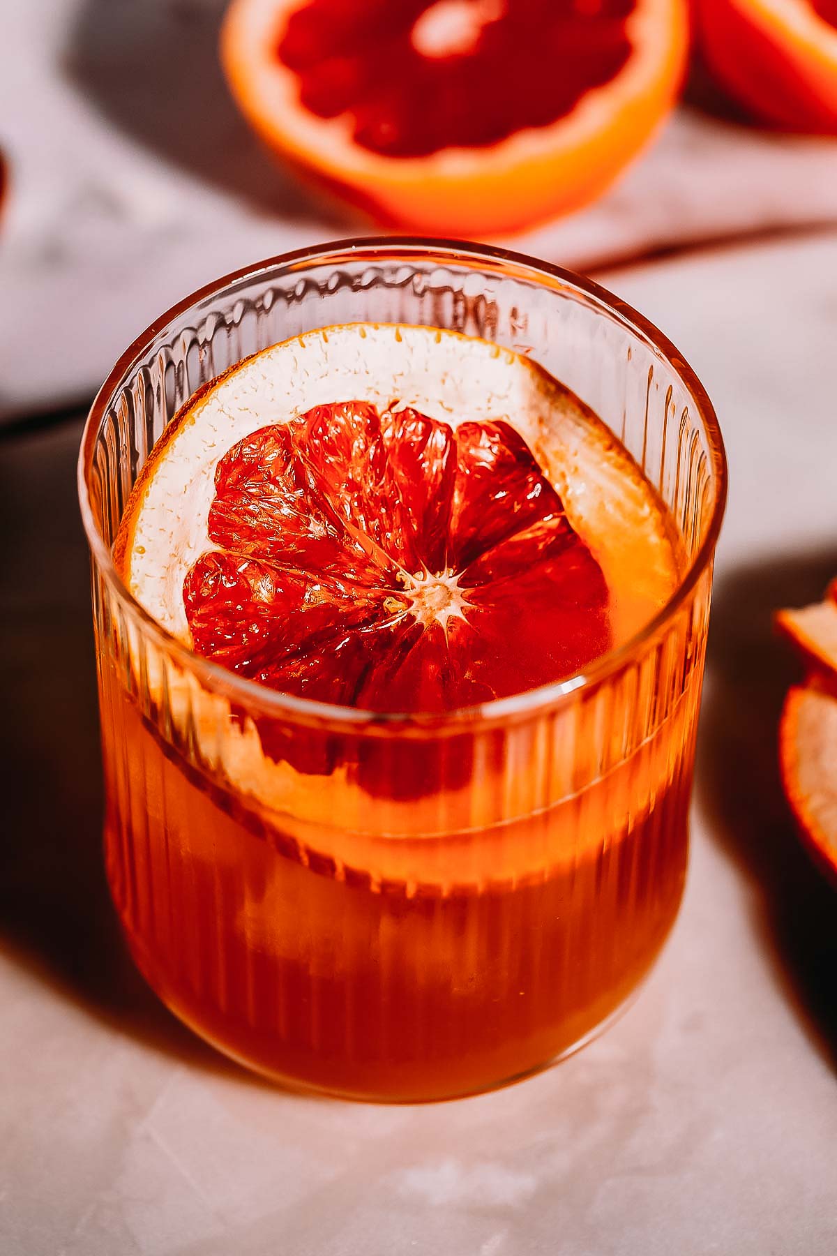 Overhead shot of a grapefruit garnish in a cocktail glass.