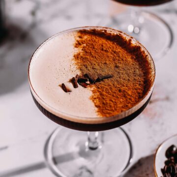 A coupe glass with an espresso martini dusted with chai spices.