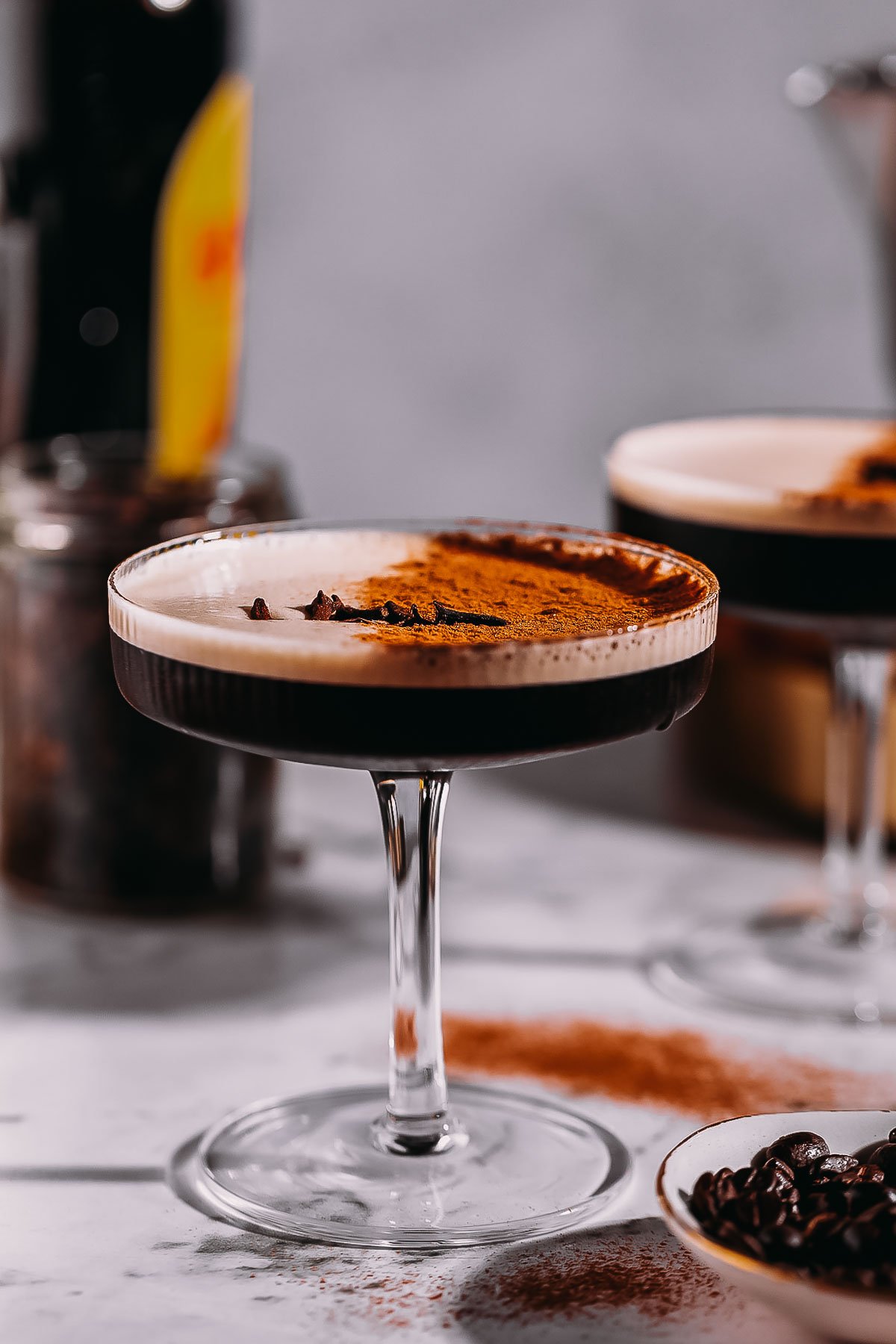 Side angle of a coupe glass filled with a frothy chai espresso martini.