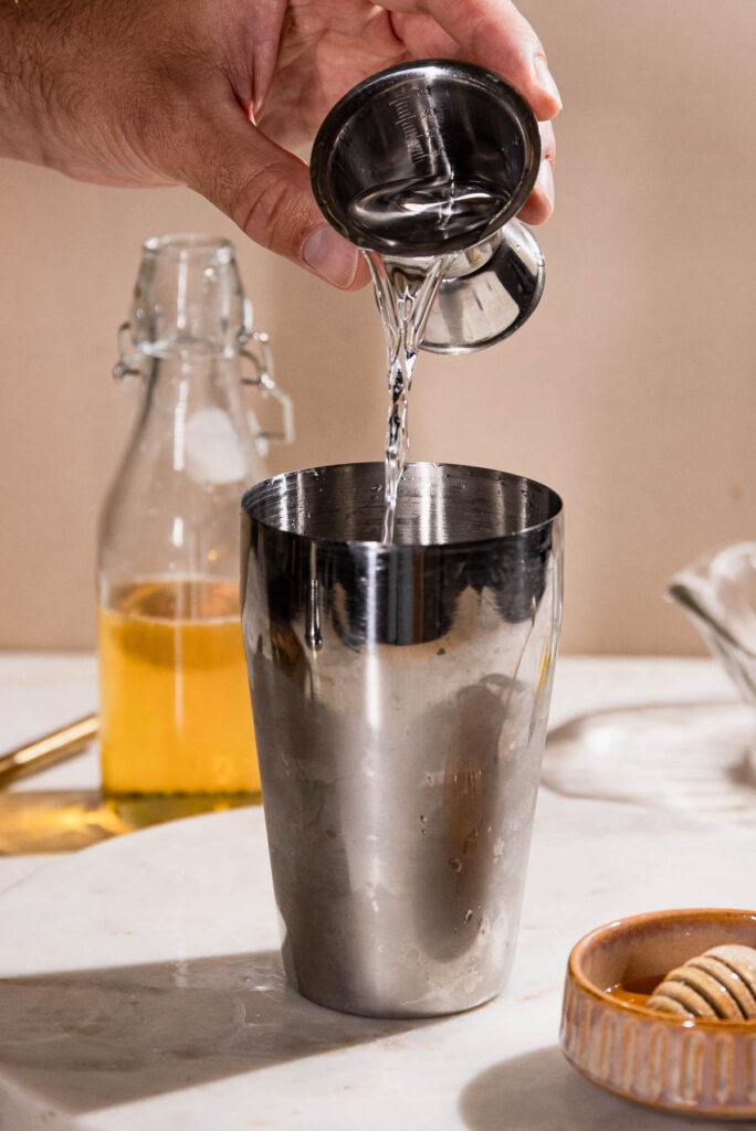 Gin being poured into a cocktail glass. 