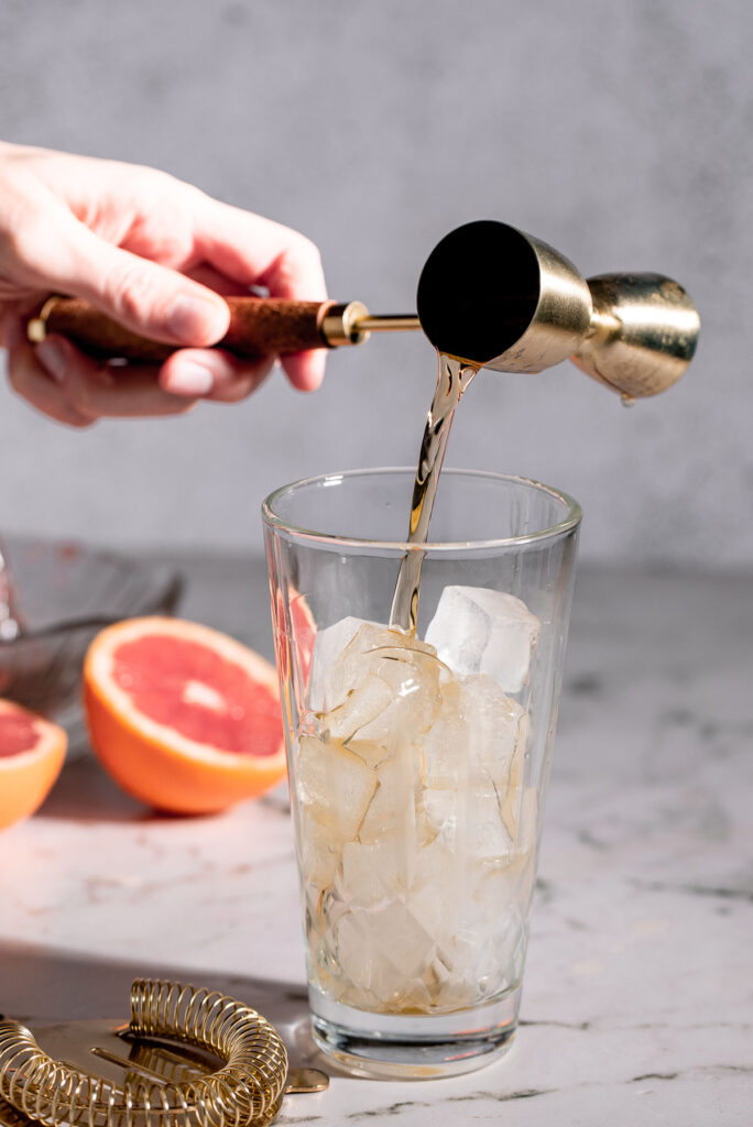 Pouring bourbon into a cocktail shaker. 