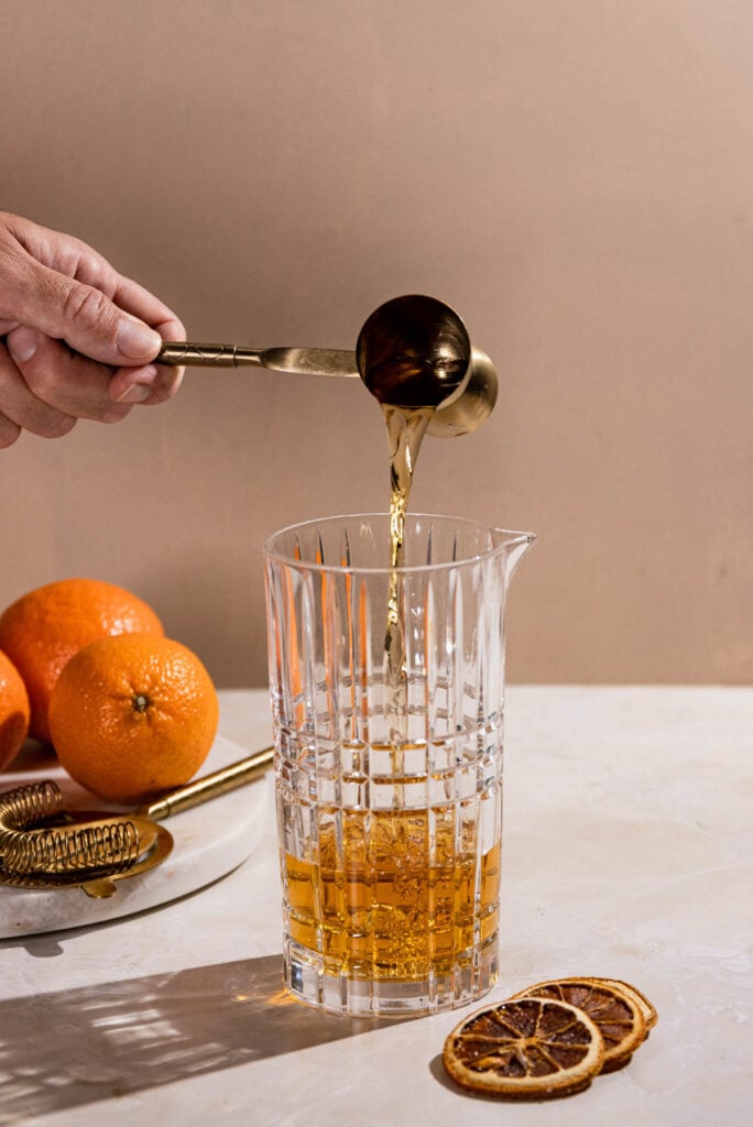 Rum being poured into a cocktail shaker. 