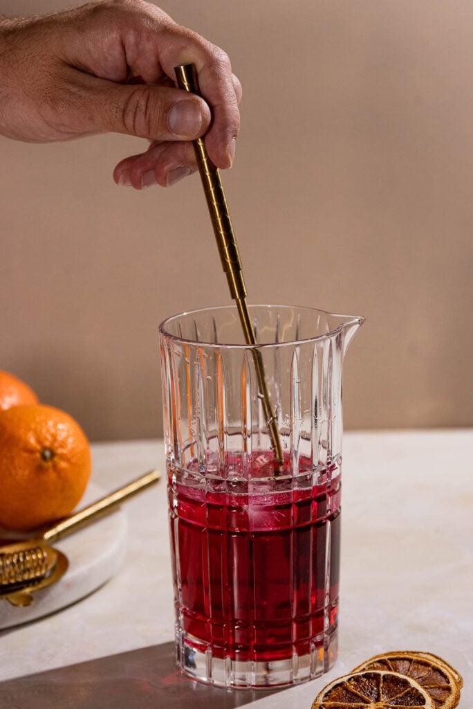 Hand stirring cocktail in a cocktail shaker. 