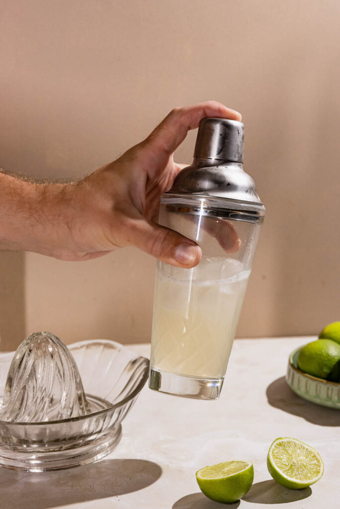 Hand shaking a cocktail shaker. 