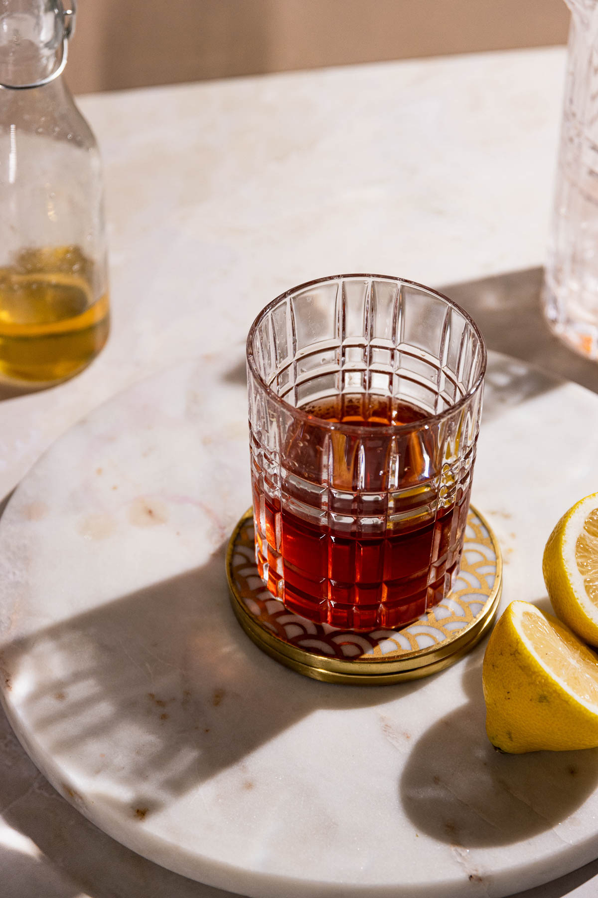 Long shadow coming off a sazerac cocktail in a rocks glass.