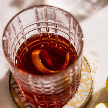 Overhead shot of a sazerac cocktail to show orange twist in the highball glass.