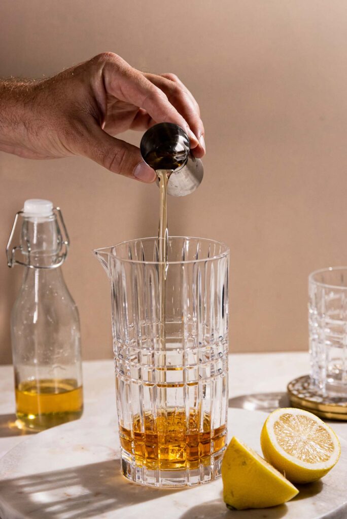 Simple syrup being added to a cocktail sha