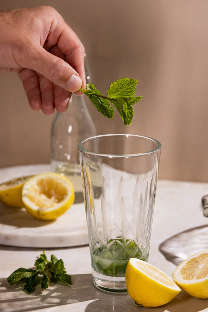 Mint added to a cocktail shaker. 