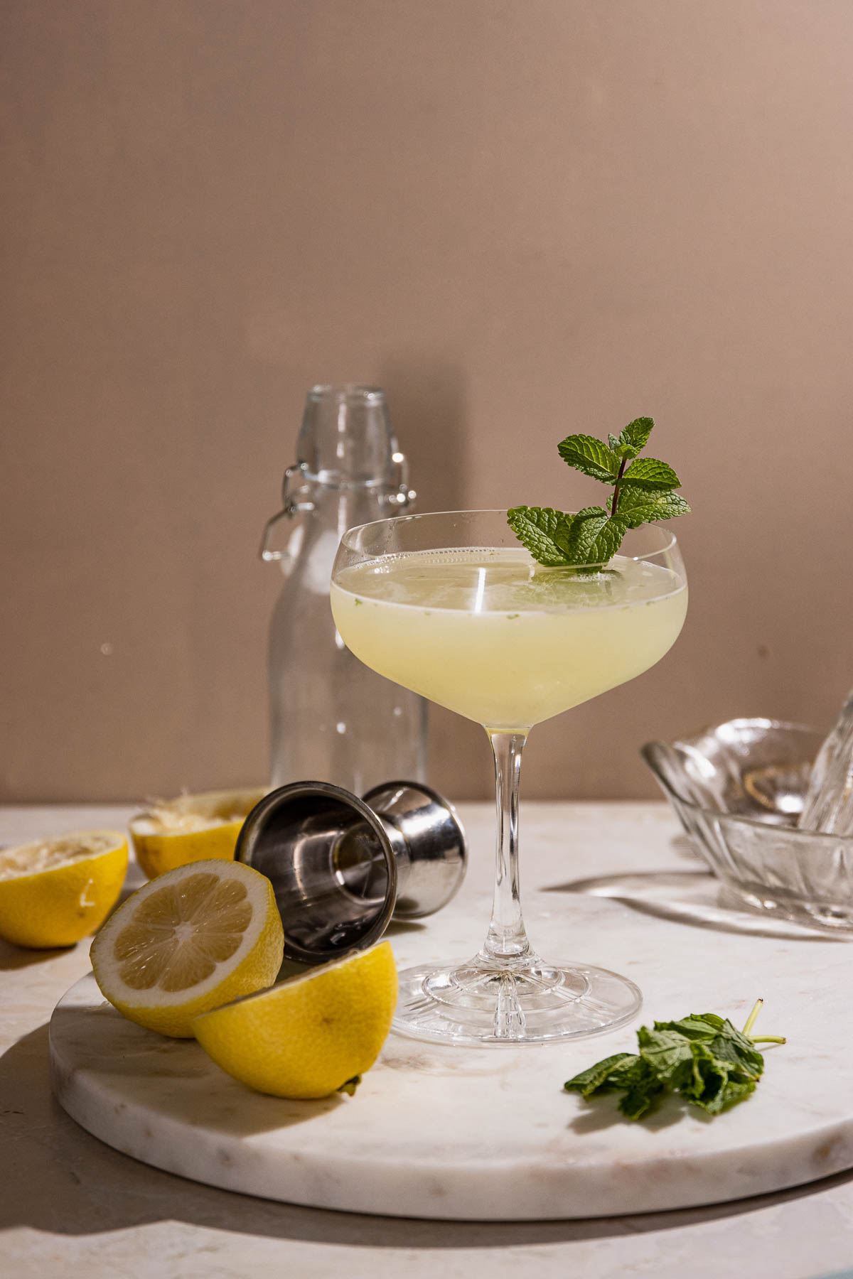 Smooth shot of southside cocktail , mint, lemons and cocktail tools on a table. 