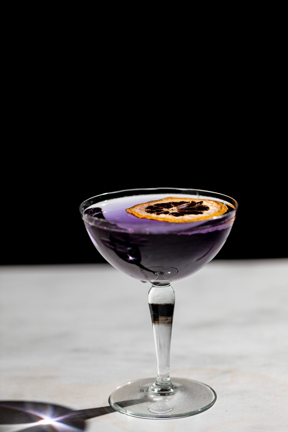 Side shot of a violet aviation gin cocktail.