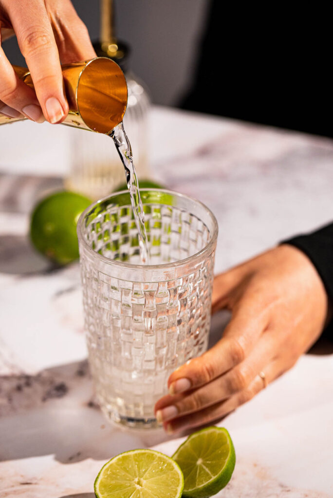 Close up of mezcal pouring from jigger.